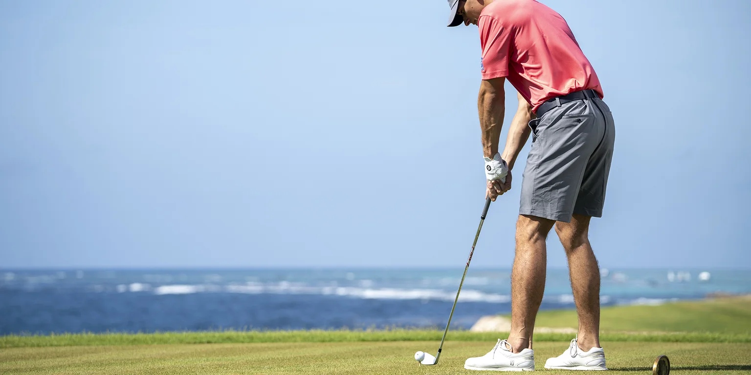 Golfer preparing a putt beside the Caribbean at Corales Golf Course