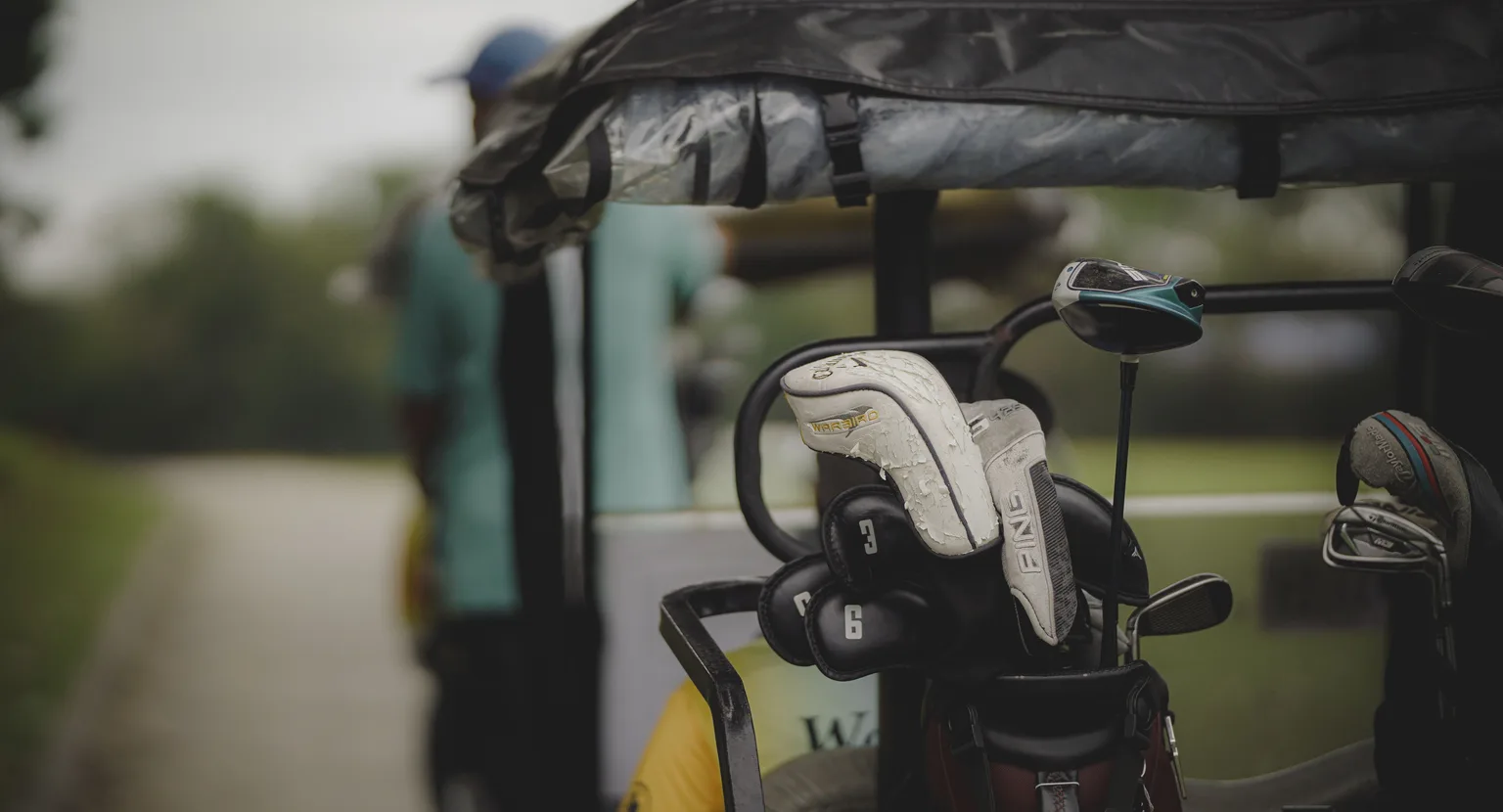 Golf clubs secured on a cart at a green course