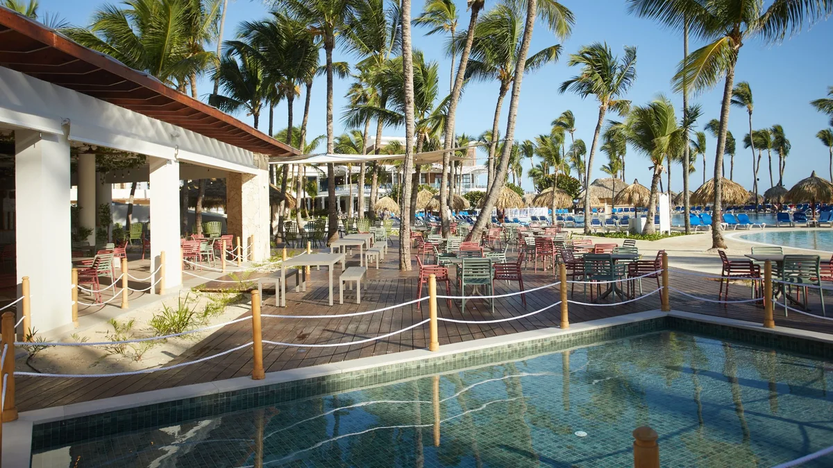 Outdoor dining terrace beside the pools at Bahia Principe Escape Ambar