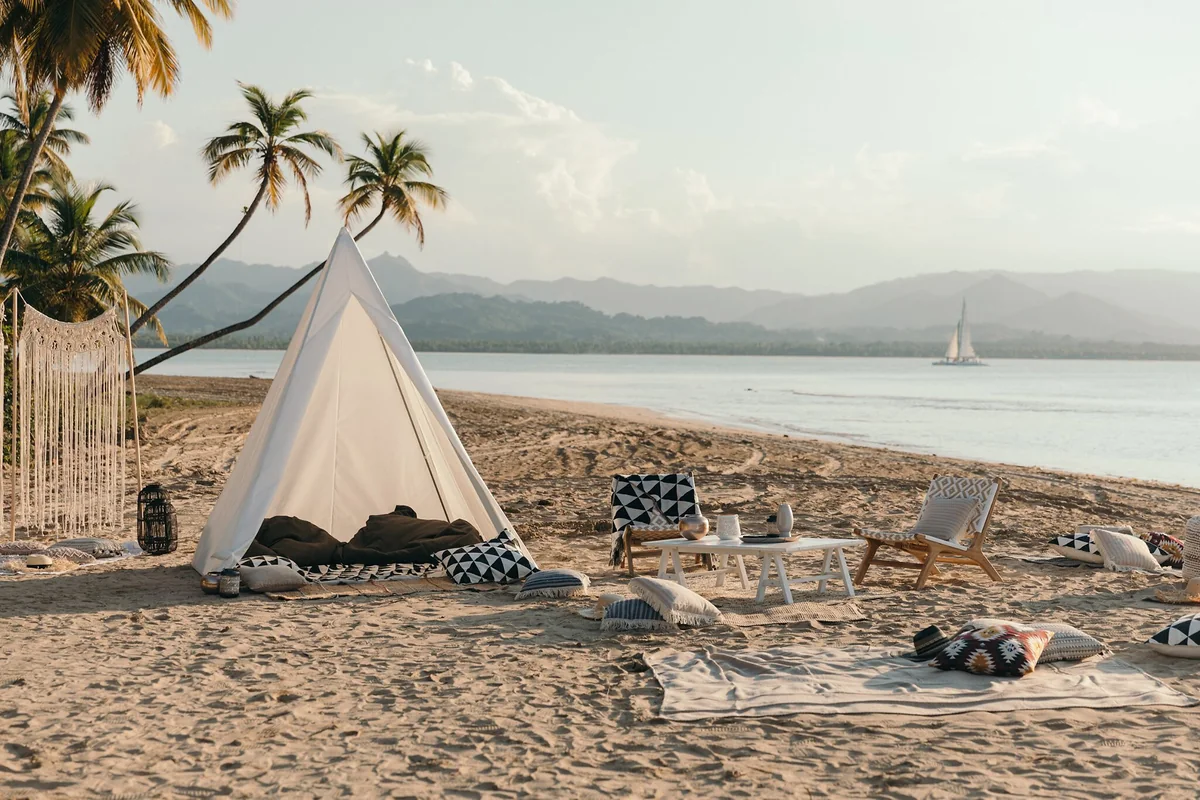 Beach seating with palms, water and distant mountains in the Club Med Michès gallery