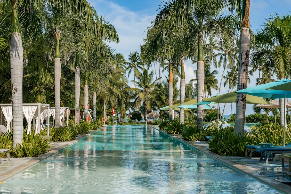 Long swimming pool lined with palms at Club Med Michès Playa Esmeralda