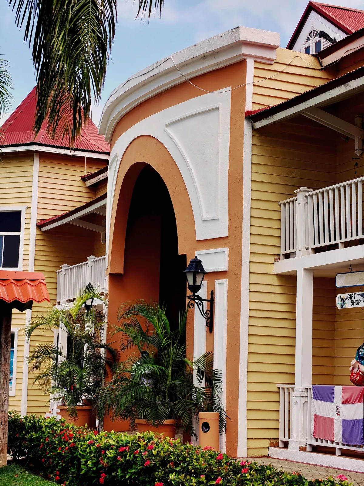 Caribbean resort exterior with palms and an arched entrance