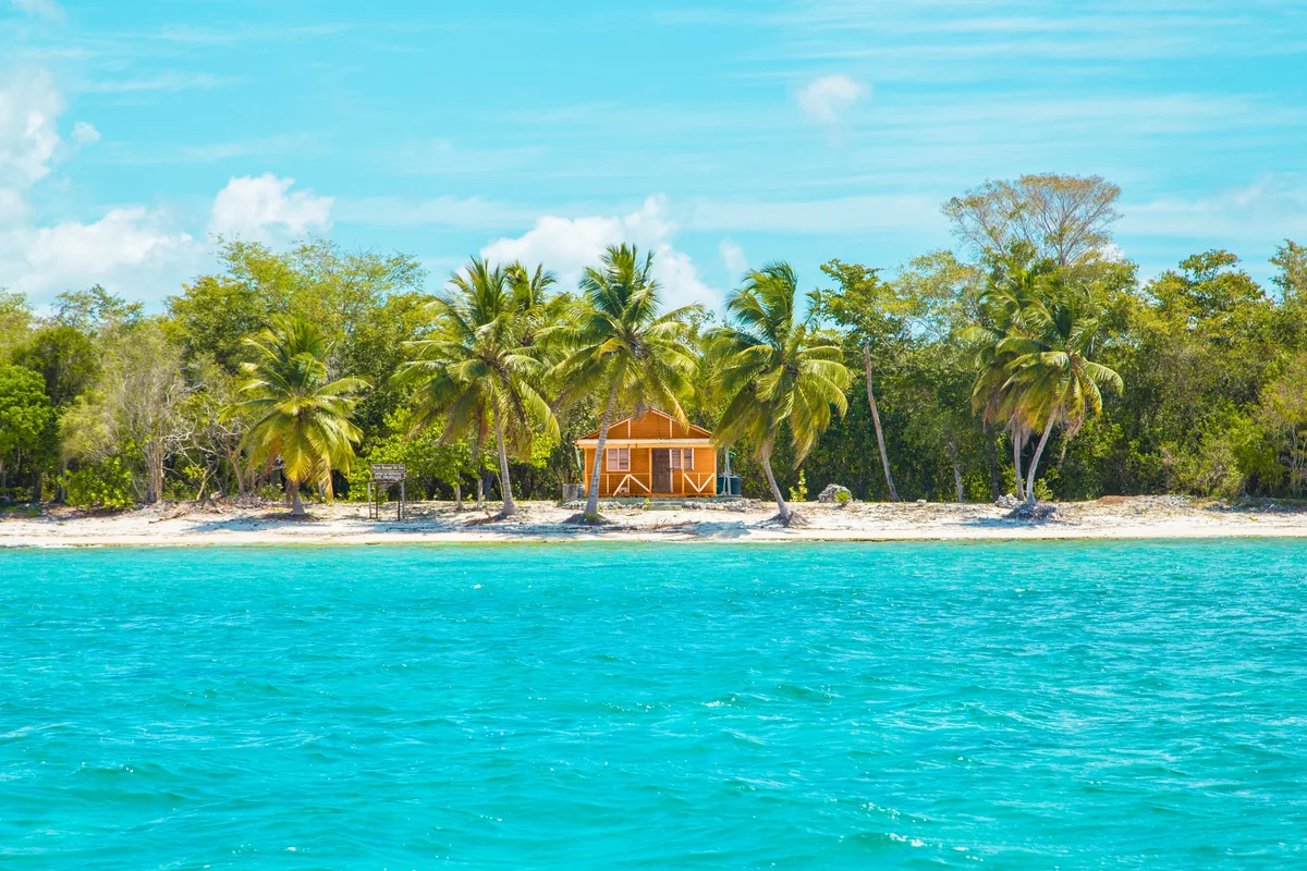 Palm-lined beach hut and turquoise water in La Altagracia