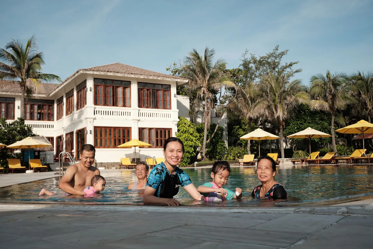 Family beside a generic resort pool for family-trip planning context