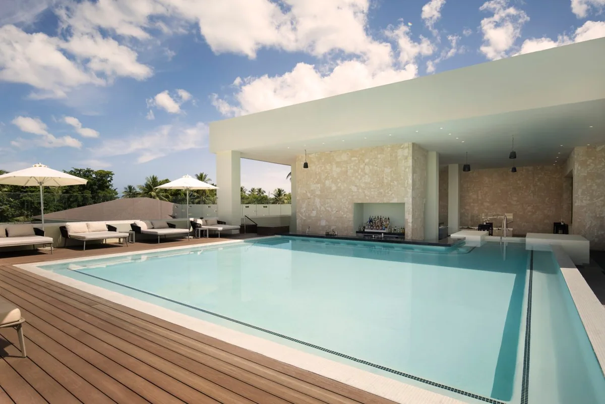 Rooftop pool with deck loungers and a shaded area at Marriott Miches Beach
