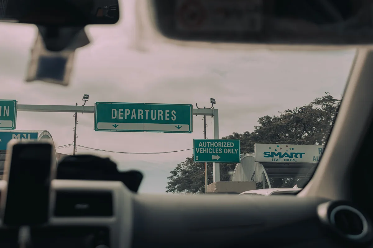 Airport-direction sign seen through a windshield for generic departure-planning context