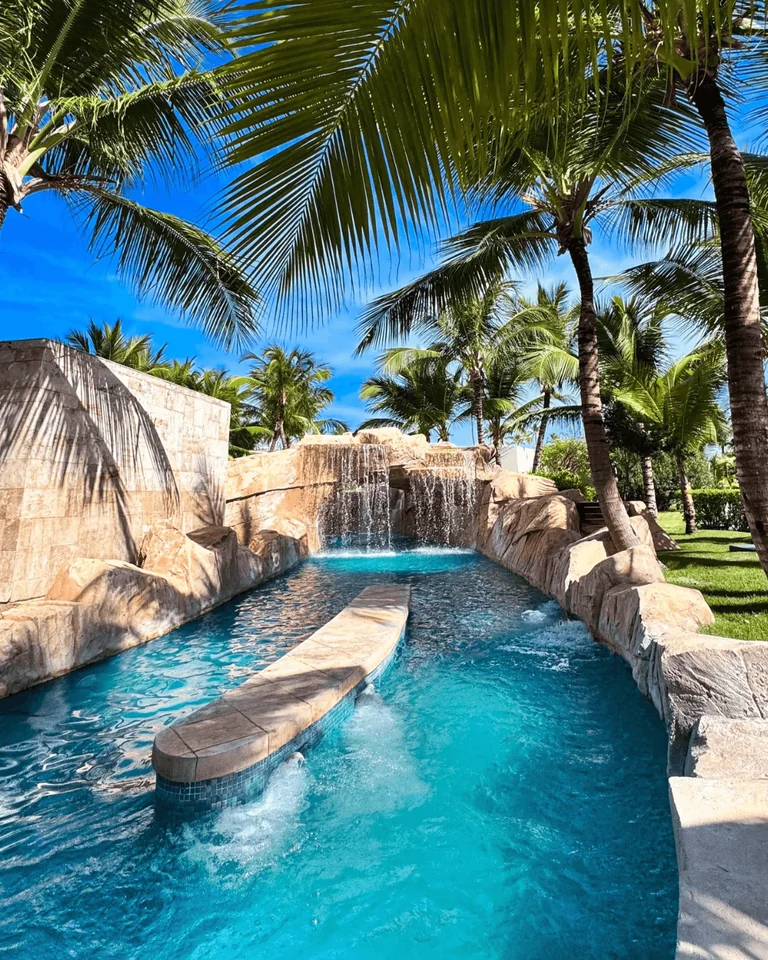 Lazy river and waterfall among palm trees at Royalton Bavaro