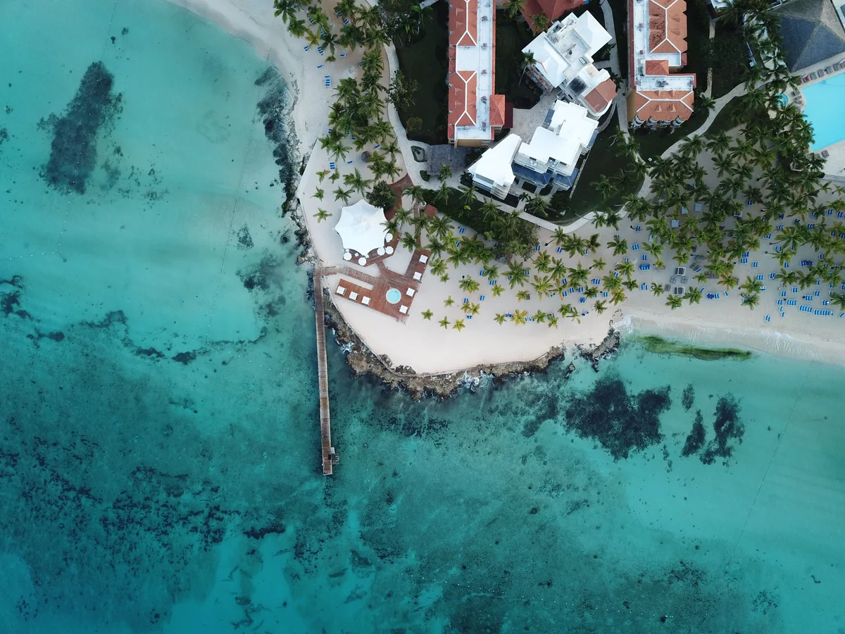 Aerial view of a Dominican Republic beach with resort buildings and turquoise water