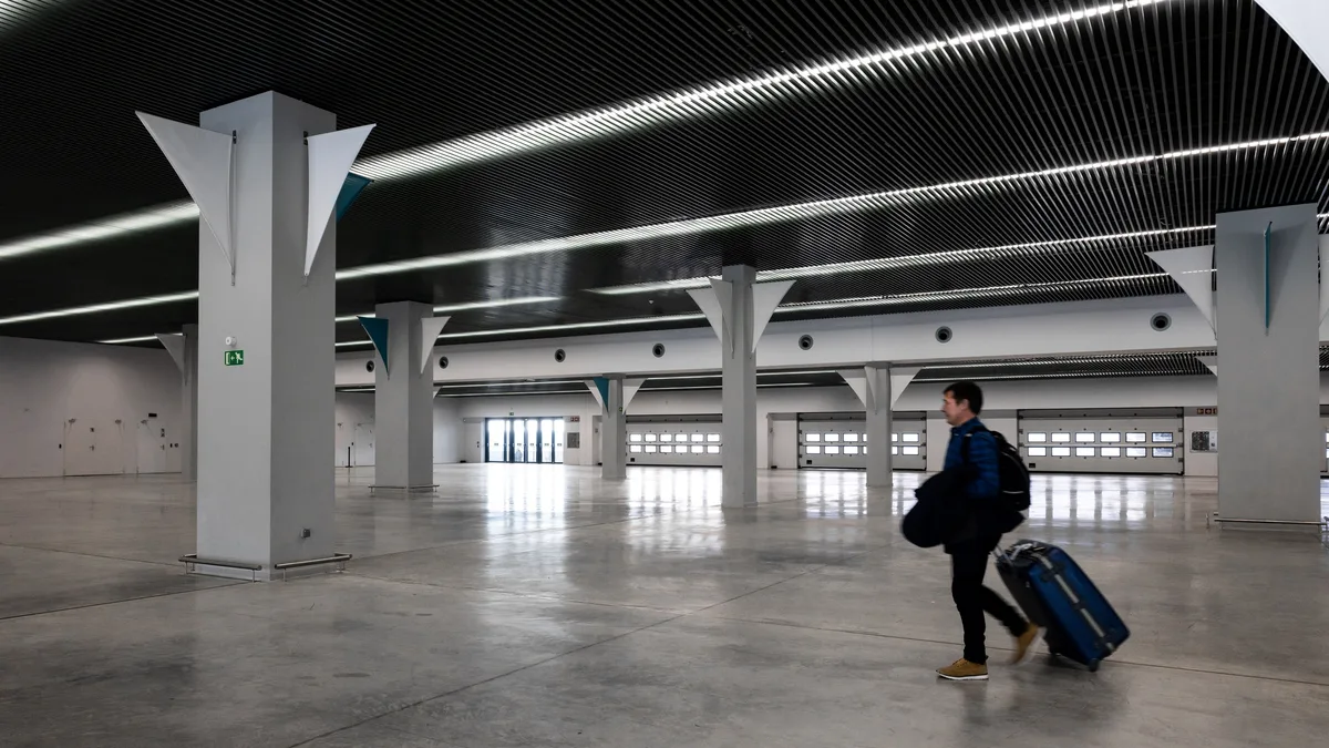 Traveller with luggage in a generic airport hall for return-planning context