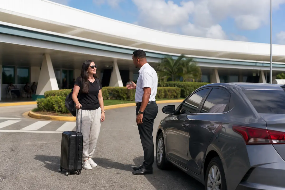 Traveller meeting a driver outside a compact regional airport in Santo Domingo