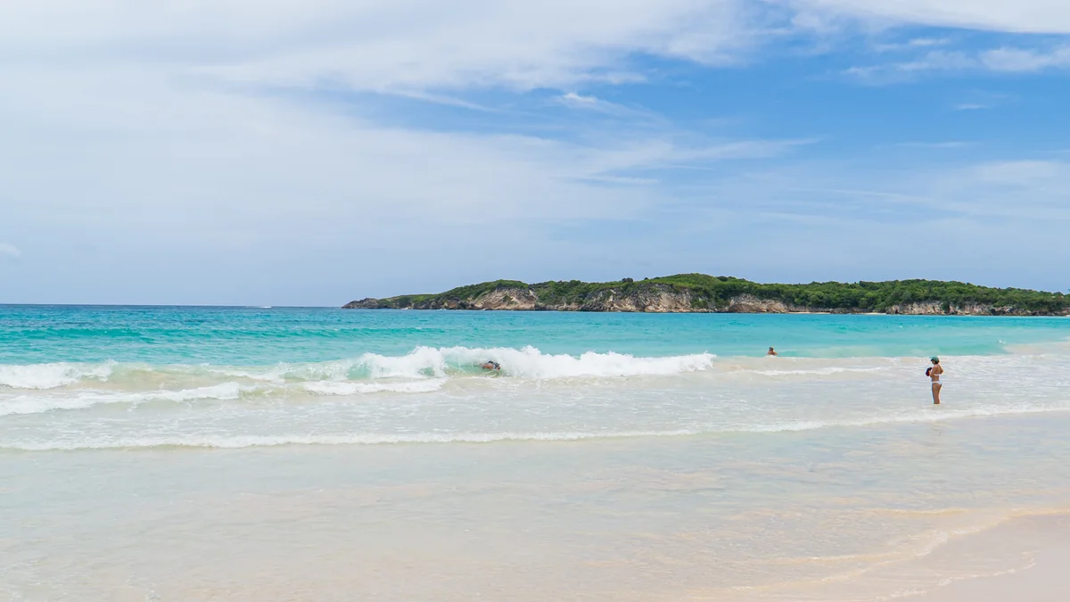 Breaking surf along the Macao Beach waterline and low coastal headland