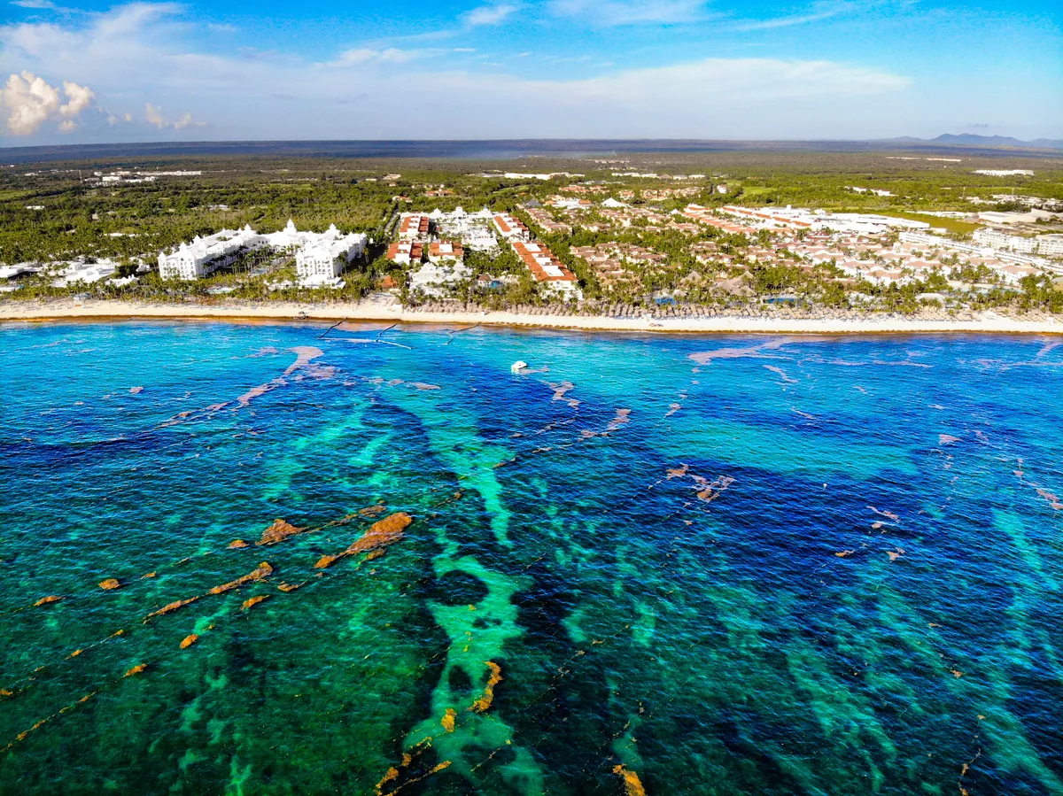 Aerial view of a Dominican Republic coastal settlement beside clear blue water