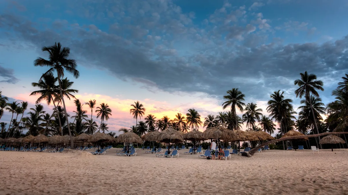 Palm-lined beach at sunset in Bávaro for return-planning context