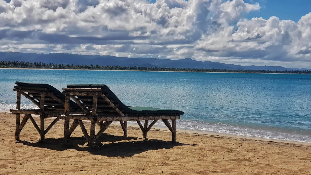 Wooden beachfront shelter, turquoise water and mountain backdrop at Playa Esmeralda